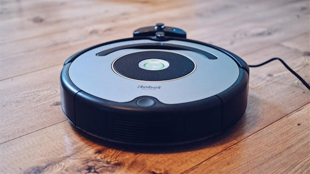 iRobot robotic vacuum cleaner navigating a room, automated smart cleaning device for home.