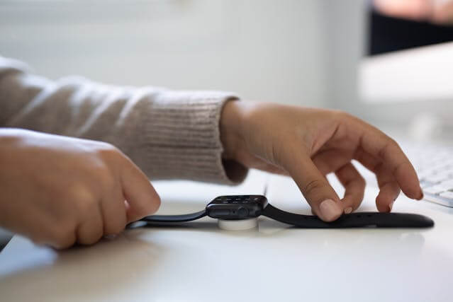 Smartwatch charging on a sleek wireless charger beside other wearable charging accessories, symbolizing efficient power solutions