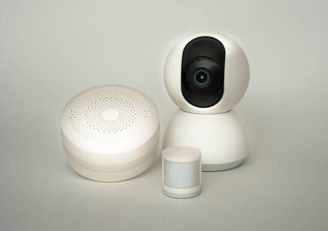 Smart home security camera mounted indoors, displaying live video feed on smartphone, symbolizing home surveillance and safety technology.