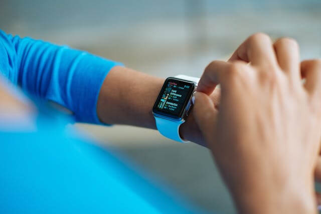 Smartwatch displaying digital time and health tracking icons on screen, symbolizing modern wearable technology.